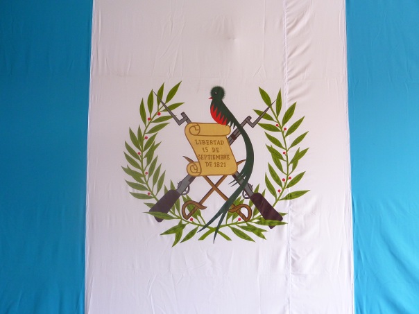 The blue stripes represent the Pacific and Atlantic Oceans. The motto reads "Libertad 15 Septiembre de 1821", when Guatemala became independent from Spain, and the Quetzal is the national bird.